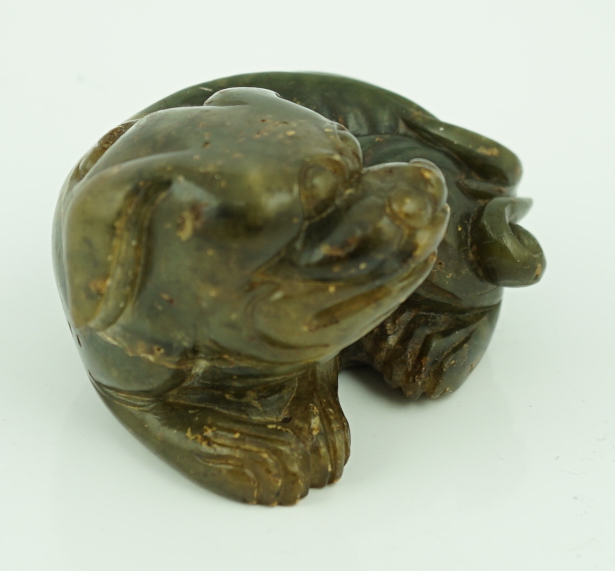 A Chinese Ming green soapstone figure of a recumbent lion-dog, 16th/17th century